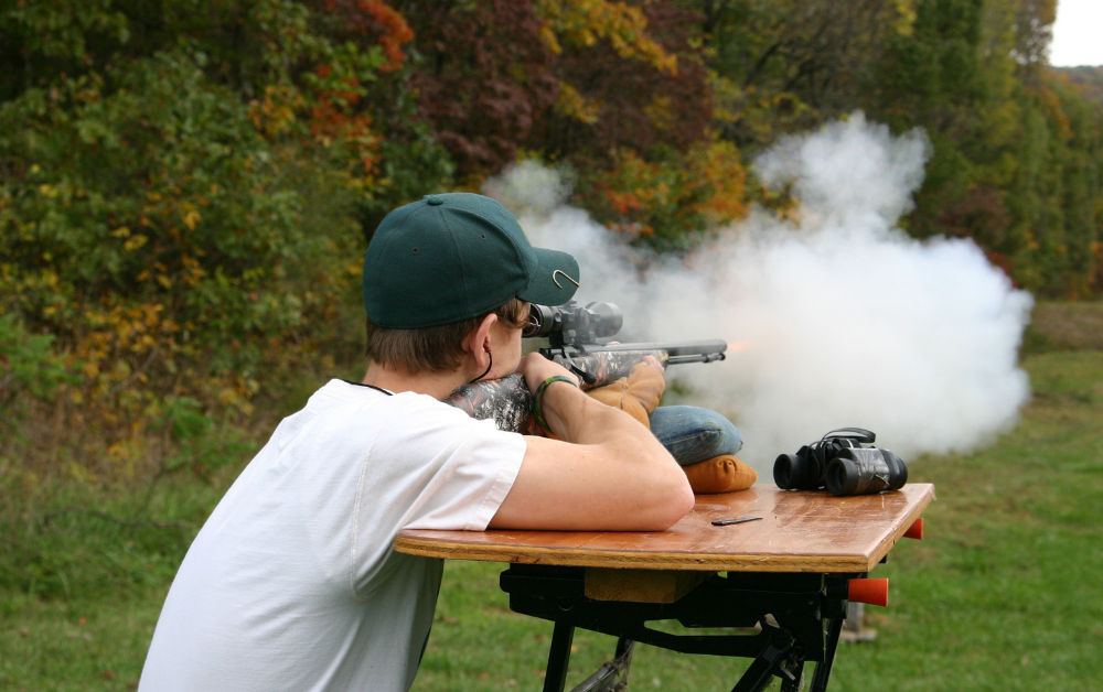 Man Firing Rifle with a scope at a target